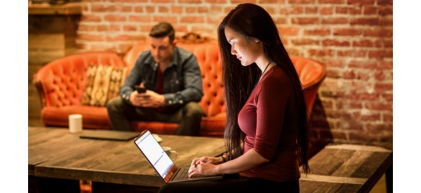 Studentin am Laptop und Student auf der Couch